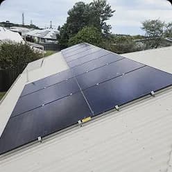 Black solar panels on a pale metal roof in Innes Park, QLD