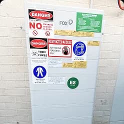 Fox ESS battery with safety signage on a rendered wall in Maudsland, QLD
