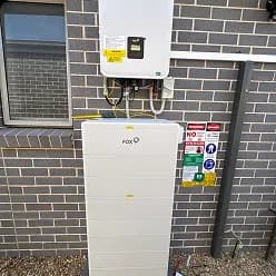 Fox ESS battery mounted below an inverter on a brick wall in Werrington, NSW