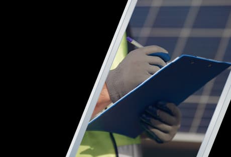 A solar technician reviewing a checklist on a clipboard during a residential solar panel installation